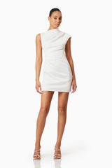 Brunette model wearing Rose Asymmetrical Mini Dress In White posed shot