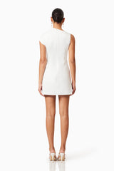 Brunette model wearing Rose Asymmetrical Mini Dress In White back shot