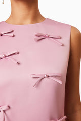 Brunette model wearing Rose Shift Bow Dress in Pink detail shot